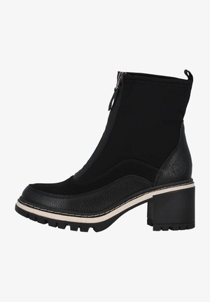 Bottine noire à la cheville avec talon épais, fermeture éclair avant, semelle intercalaire en cuir texturé et semelle extérieure épaisse à crampons, conçue pour un usage décontracté ou en extérieur.