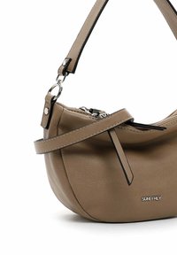 Borsa a spalla in finta pelle marrone con una forma curva, dettagli neri, tracolla regolabile e metalleria argentata. Presenta una chiusura con zip.