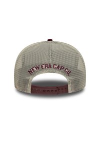 Cappellino da baseball con retro in rete e una fusibilit maroon. "NEW ERA CAP CO" ricamato in maroon sul retro. Colore beige.