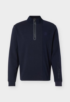 Mornarsko plavi pulover s dugim rukavima, prednjim otvorom na pola patentnog zatvarača, visokim ovratnikom, rebrastim manšetama i suptilnim logotipom na prsima i desnoj rukavici.