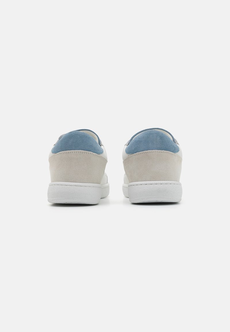 Sneakers con una toma superiore in suede grigio chiaro e un accento in suede blu sul tallone, suola in gomma bianca e design minimalista.