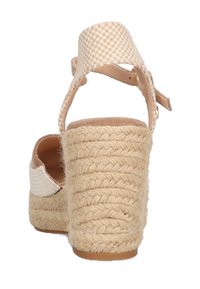 Sandalia de cuña de esparto beige con tiras de tobillo de tejido texturizado, tacón de yute trenzado y plantilla suave color marrón claro. Cierre con hebilla ajustable.