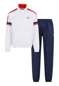 White athletic jacket with red and navy accents, zip closure, and elastic cuffs paired with navy pants, featuring a drawstring waist.