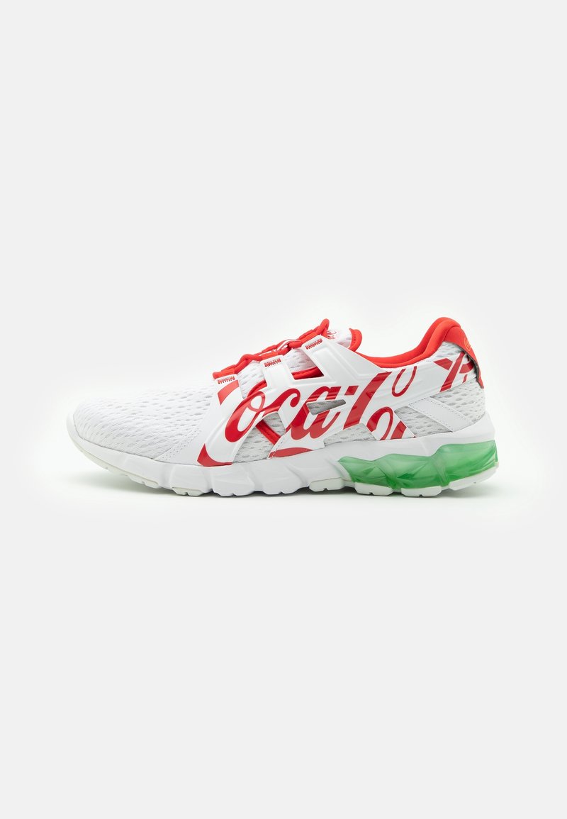 Vit sportskor med röda detaljer och strukturerad mesh-ovandel. Har en framträdande röd Coca-Cola-logotyp och en grön genomskinlig sula.