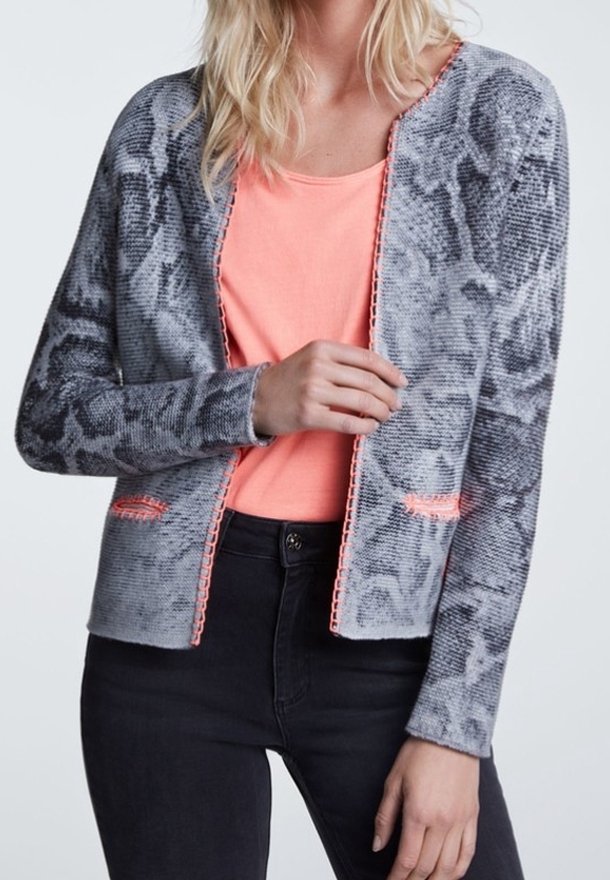 Cardigan tricot à imprimé serpent gris avec des accents orange. Il présente une coupe décontractée et un design ouvert à l'avant, associé à un t-shirt rose en dessous.