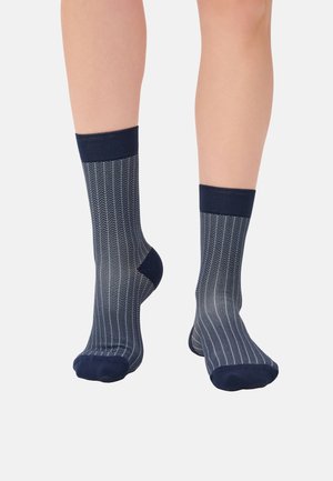 Navy blue patterned socks featuring a chevron design with a ribbed cuff and soft texture, extending to mid-calf.