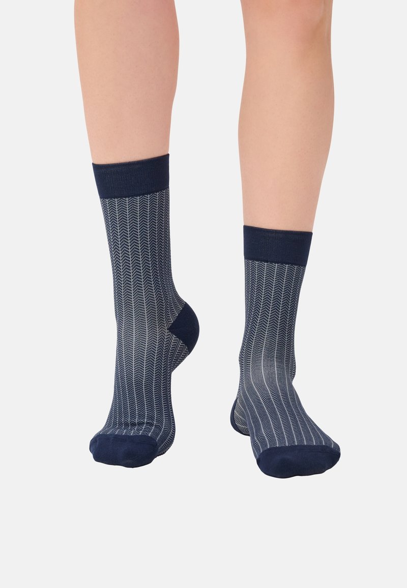 Navy blue patterned socks featuring a chevron design with a ribbed cuff and soft texture, extending to mid-calf.