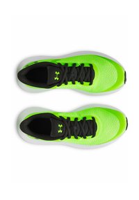 Zelené atletické topánky s sieťovaným zvrškom, čiernymi šnúrkami a textúrovanými akcentmi. Majú polstrovanú bielu podrážku a logo Under Armour na boku.