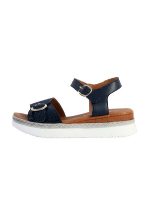 Marineblauwe leren sandalen met een gestructureerde bovenkant, een verstelbare enkelriem, een ronde gesp en een witte rubberen zool met een patroon.