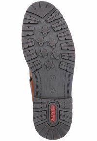 Brown leather shoe with a textured rubber sole featuring a star-shaped tread pattern, including a red logo and size markings on the outsole.