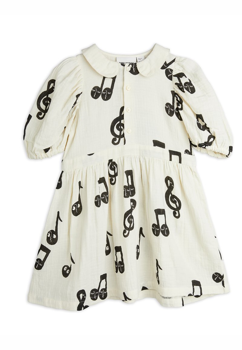 White cotton dress featuring a round collar, puff sleeves, and a gathered skirt, adorned with black music notes and clefs throughout.
