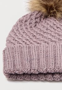 Pletená čiapka v jemnej levanduľovej farbe s rebrovanou textúrou. Na vrchu sa nachádza nadýchaný, svetlohnedý brmbolec. Prešité vzory pridávajú detail.