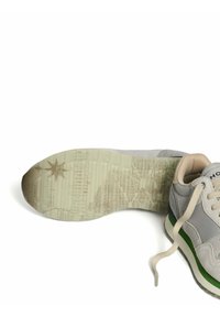 Scarpa sportiva grigia con accenti verdi, dotata di una suola in gomma testurizzata e motivi dettagliati. Lacci e materiale in morbido camoscio visibili.