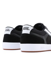 Svarta mocka- och mesh-sneakers med vita detaljer, utrustade med en gummisula och "VANS"-logotyp på hälen och sidostreifen.