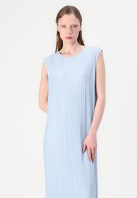 Světle modré bezrukávové šaty s vertikálními sklady, kulatým výstřihem a volným střihem. Měkká textura a minimalistický design.