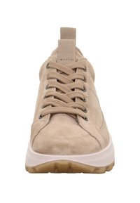 Beige Wildleder Sneaker mit dicker weißer Sohle, beigen Senkeln, metallischen Ösen und Zugschlaufe an der Zunge, von vorne gezeigt.