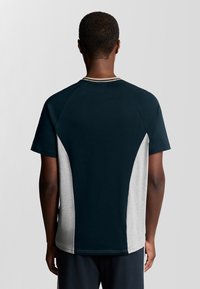 Herre T-shirt med et marineblåt design og grå sidepaneler, rund halsudskæring og korte ærmer. Stoffet ser glat ud med kontraststing.