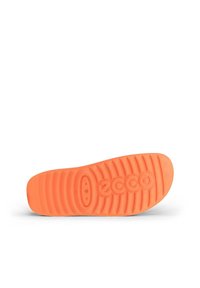 Orangene Gummisohlen mit strukturierter Oberfläche und ausgeprägten Rillen. Verfügt über ein Logo und kreisförmige Vertiefungen für besseren Halt.
