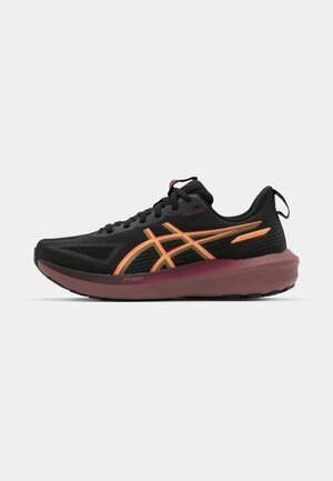 Chaussure de sport avec un dessus en maille noire, des accents orange et jaunes, et une semelle intermédiaire bordeaux. Présente un design texturé et un système de laçage.