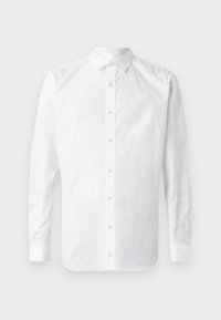 Chemise blanche à manches longues avec boutons, col pointu et poignets boutonnés, présentée sur un fond gris clair neutre.
