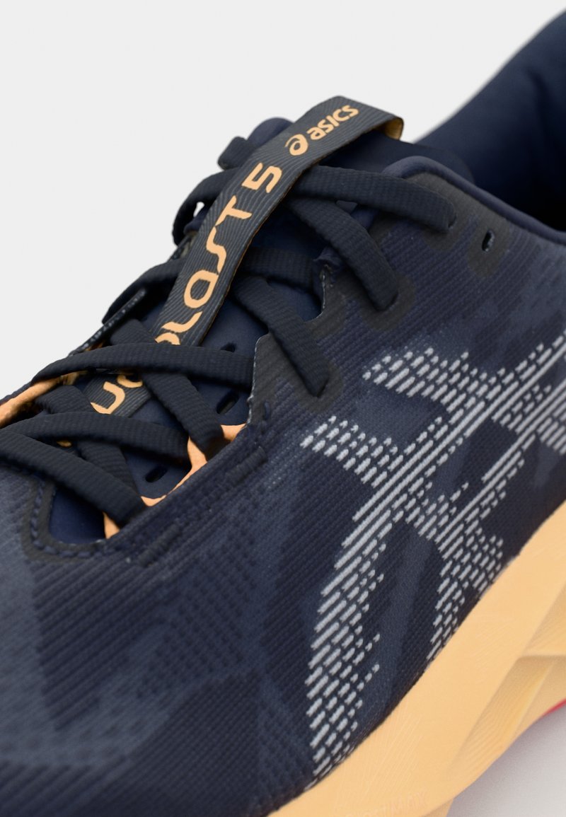 Navy running shoe with a textured upper, prominent Asics logo in light gray, and peach accents on the sole and laces.