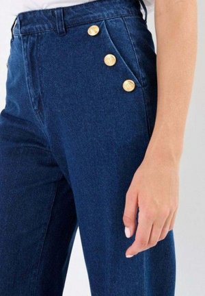 Pantaloni in denim blu scuro con vita alta, dotati di quattro bottoni dorati sul lato e una finitura in tessuto testurizzato.