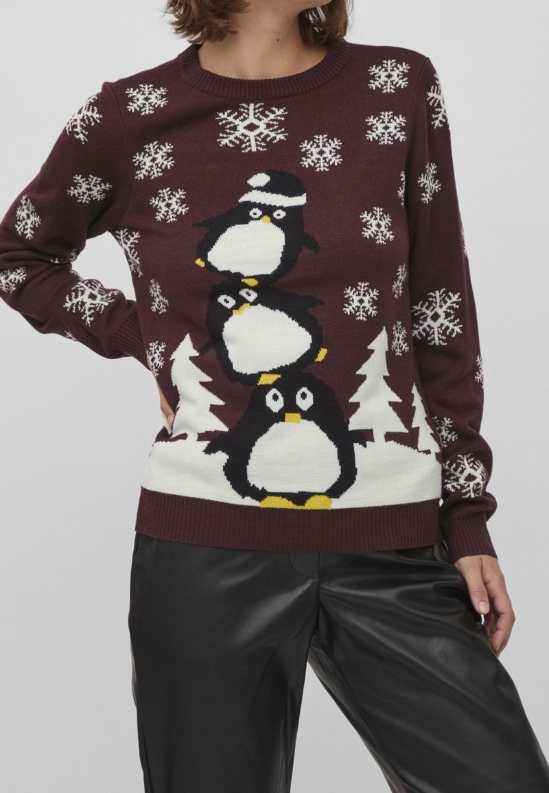 Burgundy stickad tröja med tre staplade pingviner i vitt och gult, med vita snöflingor och träd som mönster.