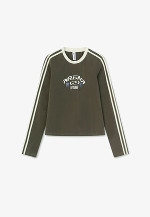 Olijfgroen shirt met lange mouwen, witte dubbele strepen op de mouwen, witte kraag en het logo "ARENA 2026 RÉSUMÉ" op de borst.