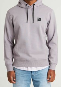 Light purple hoodie with a front pocket, black drawstrings, and a square brand logo on the chest. Soft texture, ribbed cuffs and hem.