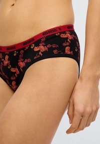 Černé bavlněné bikini s červenými květinovými vzory a detaily. Má červený elastický pas s logem „DIESEL“. Měkká textura a přiléhavý střih.