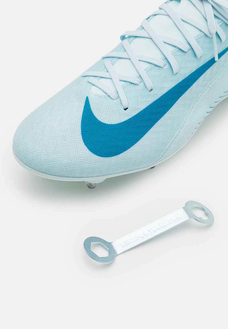 Scarpa da calcio azzurro chiaro con tomaia testurizzata, dotata di uno swoosh blu e numerosi tacchetti. Include un attrezzo argentato per regolare i tacchetti.