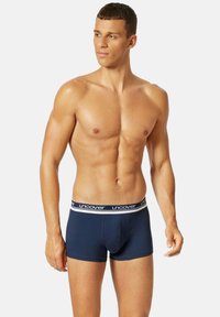 Marineblauwe katoenen boxershorts met een witte tailleband waarop het "uncover" logo staat. Strak model, zachte textuur en middellange lengte tot de bovenkant van de dij.