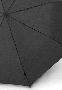 Ombrello grigio scuro con motivo tessuto strutturato, dotato di un bottone circolare sulla sommità e otto stecche rinforzate per il supporto.