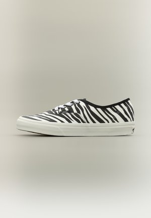 Niski but sportowy Vans z białą podeszwą i czarno-białym wzorem zebry, zaprezentowany na neutralnym tle.