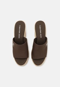 Infradito marroni con tomaia in tessuto e suola in juta stile espadrilles. Presentano un logo sulla soletta e un design a fascia larga per il comfort.