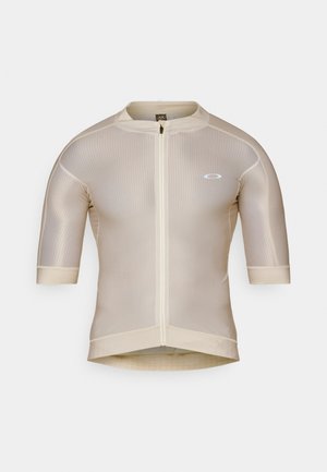 Maglia da ciclismo beige a maniche corte con zip frontale, texture in rete e piccolo logo bianco sul lato sinistro del petto.