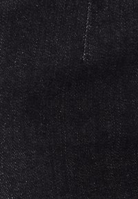 Tejido de mezclilla negro con un ligero brillo, que presenta una textura suave y detalles de costura finos. Sin patrones visibles ni acentos adicionales.