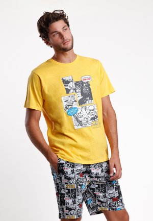 Camiseta de algodón amarilla con gráficos de estilo cómic; combinada con pantalones cortos negros que muestran vibrantes imágenes de Star Wars en un diseño de patchwork.