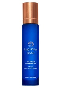 Niebieska szklana butelka z metalową, złotą nakrętką, oznaczona etykietą "Augustinus Bader The Cream Cleansing Gel," 100 ml, gładka tekstura, minimalistyczny design.