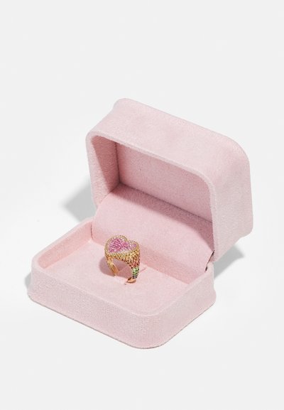 Gold heart-shaped ring with pink and green gemstone accents, displayed in a soft pink fabric-covered box.