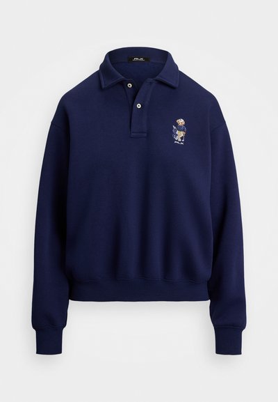 Sweatshirt polo azul-marinho feito de algodão. Apresenta um decote com gola, dois botões e um design bordado no lado esquerdo do peito.