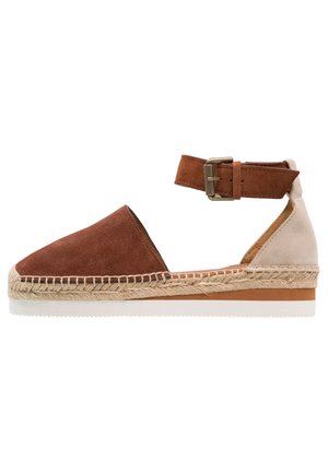 Brune og beige ruskindsespadrille med en vævet jutesål, ankelrem med spænde og et rundt tådesign.
