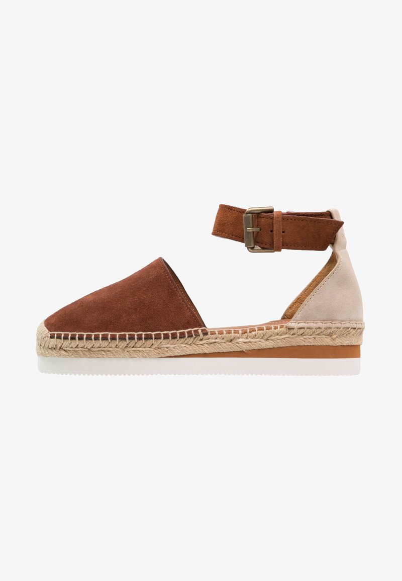 Espadrille en suède marron et beige avec une semelle en jute tissée, une bride de cheville avec boucle et un design à bout rond.
