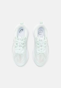 Bottines de sport vert clair avec une tige en mesh, un col rembourré et une semelle blanche. Présente un design à lacets et de subtils motifs triangulaires.