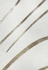 Weißer Stoff mit metallisch goldenen Wellenlinien. Die Textur wirkt glatt mit einem leicht reflektierenden Finish. Subtile, ineinandergreifende Muster.