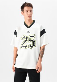 White short-sleeve jersey with black and green accents, featuring a large black "25" graphic. Made from breathable fabric, relaxed fit.