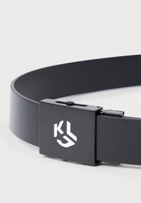 Cinto preto com uma textura suave, apresentando um acabamento mate, uma fivela retangular com um logotipo e um mecanismo de fecho ajustável.