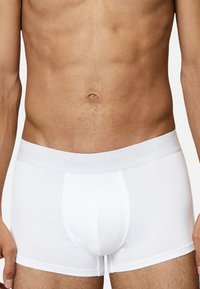 Weiße Boxerbriefe aus weicher Baumwolle, mit einem grauen Logo-Bund, eng anliegend und mit glatter Textur.