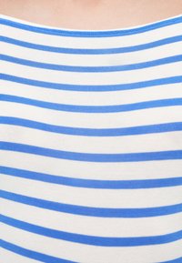 Μπλούζα με μπλε και άσπρες ρίγες, κατασκευασμένη από απαλό, ελαστικό ύφασμα, με στρογγυλή λαιμόκοψη και ομοιόμορφες οριζόντιες ρίγες διαφορετικού πάχους.