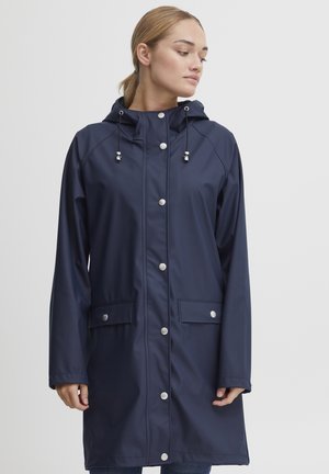 Imperméable marine, résistant à l'eau, avec une fermeture éclair à l'avant, des fermetures à pression, une capuche ajustable et deux poches avant. Texture lisse avec une coupe décontractée.